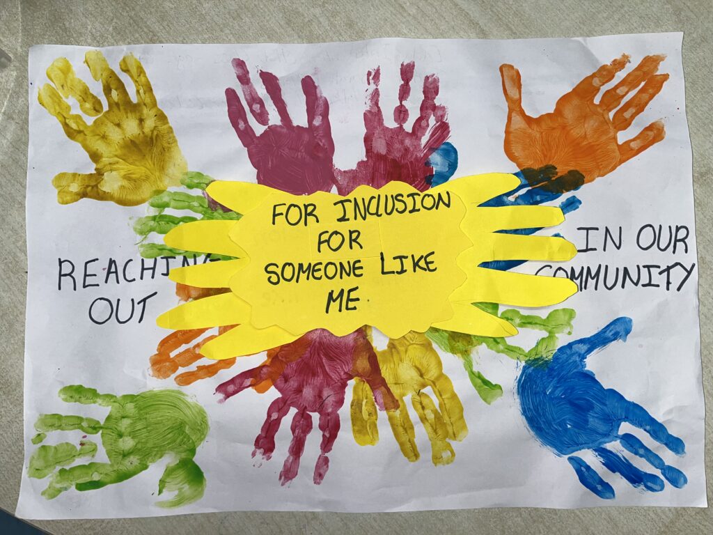 A piece of paper with hand prints and a yellow sign